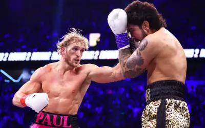 Logan Paul i Dillon Danis i boxningsring. Logan Paul slår, Dillon Danis försvarar sig.