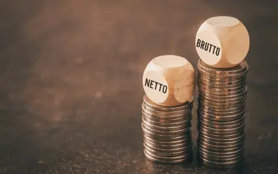Dwie wieże monet, jedna z kostką "NETTO", druga z "BRUTTO". Czy to odzwierciedla średnią krajową netto?