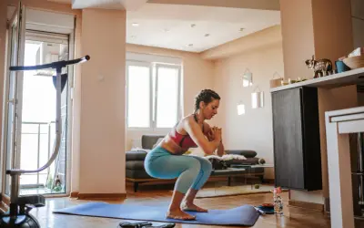 Frau macht Kniebeugen auf einer Matte, ein Beispiel für effektives **Eigengewicht Training** zu Hause.