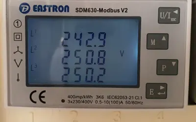 Odczyt licznika pokazuje napięcia L1, L2, L3: 242.9V, 250.8V, 250.2V. Wniosek o obniżenie napięcia w sieci jest uzasadniony.