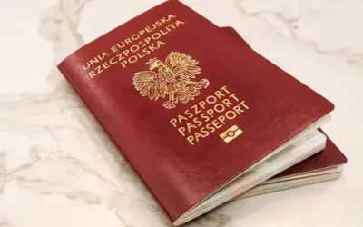 Dwa polskie paszporty, symbole wolności podróżowania i jedne z najsilniejszych paszportów na świecie, leżą na marmurowym blacie.