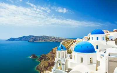 Santorini, Grecja. Białe domy z niebieskimi kopułami nad morzem. Sprawdź ceny wakacji!