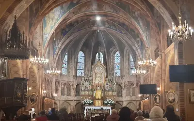 Wnętrze bazyliki z ołtarzem, gdzie króluje Matka Boska Gietrzwałdzka. Witraże i malowidła zdobią sklepienie.