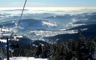 Blick vom Sessellift im Rokytnice Skigebiet auf verschneite Berge und Täler.