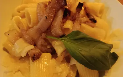 Makaron z chrupiącym guanciale, parmezanem i listkiem bazylii. To właśnie guanciale nadaje daniu wyjątkowy smak.