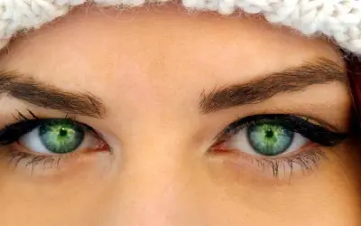 Oczy z zieloną tęczówką, podkreślone eyelinerem i tuszem, idealne dla tych, które szukają odpowiedzi na pytanie: jakie rzęsy do opadającej powieki.