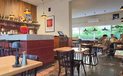 Wnętrze restauracji z barem, stołami i ludźmi jedzącymi posiłek. Klimatyczna restauracja it.