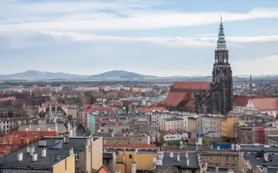 Widok na Świdnicę z dominującą wieżą katedry. Miasto oferuje wiele atrakcji, w tym zabytkową architekturę i malownicze krajobrazy.