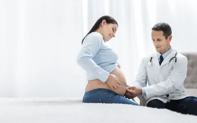 Ciąża pod opieką dobrego ginekologa w Warszawie NFZ. Lekarz mierzy obwód brzucha pacjentki.