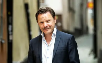 Kasper Sulocki, en man med mustasch, bär en mörkblå rutig kavaj och vit skjorta i en gränd.