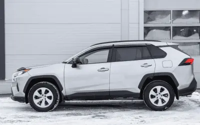 Srebrny crossover stoi na śniegu. To idealny samochód na zimowe wyprawy, bo to właśnie crossover co to za auto, które łączy cechy SUV-a i kombi.