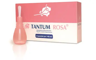 Tantum Rosa, lek dopochwowy w płynie, w różowej buteleczce z aplikatorem, obok pudełka z różą.