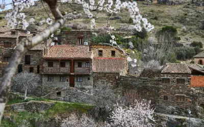 Casas de piedra con tejados rojos en un pueblo de montaña, ideal para saber como ir a la sierra de Madrid en primavera.