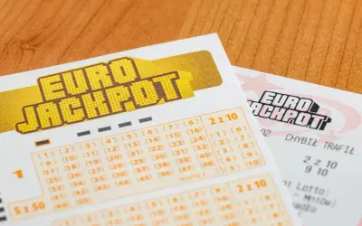 Kupony Eurojackpot na drewnianym tle. Zastanawiasz się, dlaczego Polska dołączyła do Eurojackpot tak późno w porównaniu do sąsiadów?