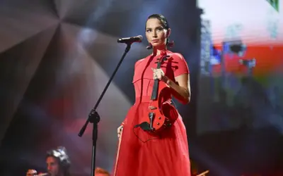 Mery Spolsky na koncercie w czerwonej sukni, trzymająca czerwoną gitarę elektryczną.