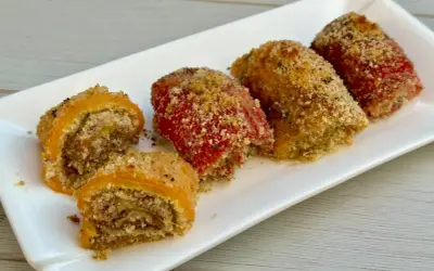 Involtini di peperoni ripieni e gratinati, serviti su un piatto bianco.
