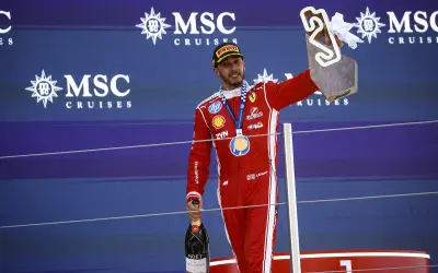Lewis Hamilton celebra su victoria en el podio, con trofeo y champán. Su edad no se refleja en su energía.