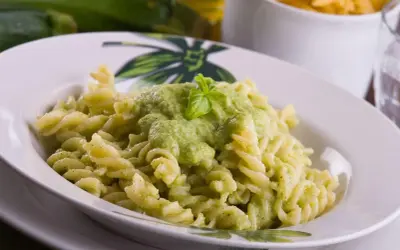 Fusilli z kremowym, zielonym sosem z cukinii, udekorowane listkiem bazylii. Pyszny sos z cukinii do makaronu.