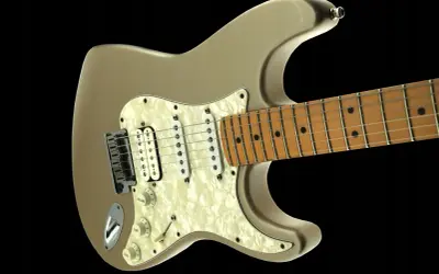 Złota elektryczna gitara, jakby wybiegły z niej dźwięki, gotowa do rockowych popisów.