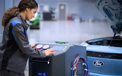 Mekaniker utför service på en Ford Focus. Maskinen indikerar att det är dags för ford focus serviceintervall.