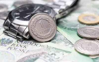 Zegarek i monety na banknotach. Czy to symbol najniższa krajowa na godzinę?