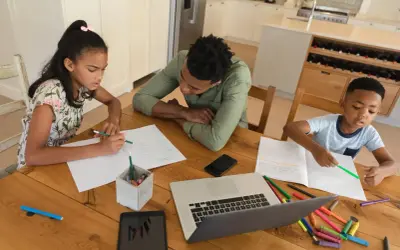 Familie lernt zu Hause. Ist Homeschooling in Deutschland erlaubt? Kinder schreiben und malen, Vater hilft.