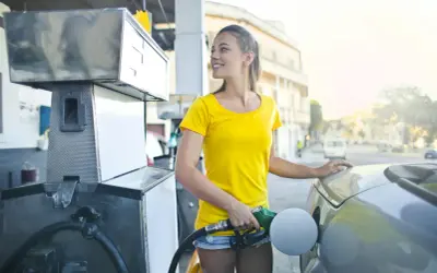 Uśmiechnięta dziewczyna tankuje auto, nalewając Vervę 98.