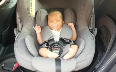 Bebé dormido en su silla de coche, un paso clave para como acostumbrar a un bebé al coche y viajar seguros.