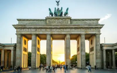 Brandenburger Tor i Berlin, en ikonisk sevärdhet som visar vad man ska se i Berlin. Solnedgången lyser upp monumentet och folklivet.