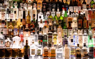 Wiele butelek alkoholu na półce. Szukając, jaki alkohol ma najmniej kalorii, warto zwrócić uwagę na te przejrzyste.