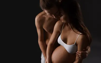 Para, obejmujący brzuch kobiety w ciąży. Czasem pojawia się brak ochoty na seks w ciąży, ale bliskość jest ważna.