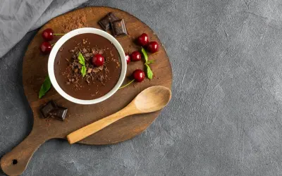 Pyszny budyń czekoladowy z wiśniami i miętą. Zastanawiasz się, ile kcal ma budyń czekoladowy? Ten deser wygląda na bogaty w smak!