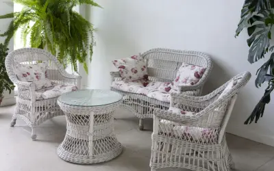 Conjunto de muebles de mimbre blanco con cojines florales, ideal para restaurar muebles de mimbre y darles un toque fresco.