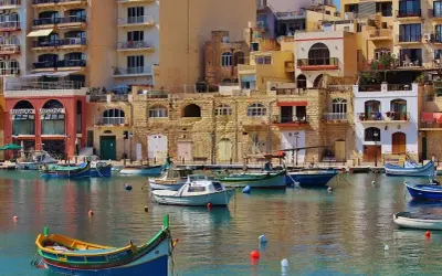 Malta, z kolorowymi łodziami i kamiennymi budynkami. Czy na Maltę potrzebny paszport? Tak, jeśli nie jesteś obywatelem UE.