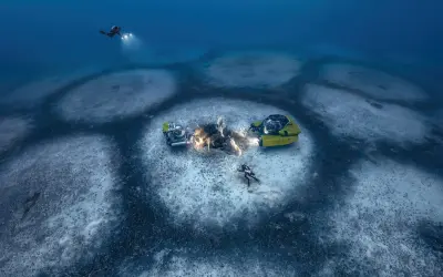 Laurent Ballesta esplora il fondale marino con mini sottomarini gialli e subacquei illuminati, scoprendo misteriosi cerchi sul fondale.