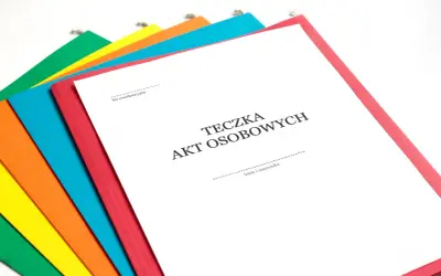 Kolorowe teczki z dokumentami, jedna z nich to Teczka Akt Osobowych część A, gotowa do wypełnienia.