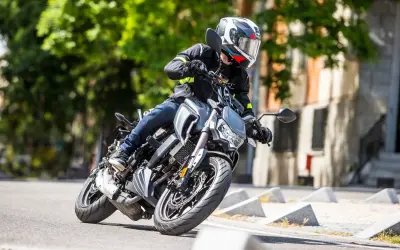 Motociclista en curva con una moto naked. Opiniones sobre la Orcal SK 01 125.