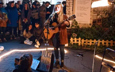 Alice Phoebe Lou spielt in Berlin vor begeistertem Publikum. Eine Lichterkette umrahmt die Bühne.