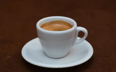 Eine Tasse mit cremigem Espresso Doppio auf einer Untertasse, bereit für den Genuss.