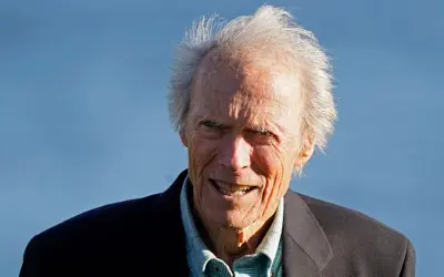 Clint Eastwood heute, mit seinem charakteristischen Lächeln und zerzaust grauem Haar, blickt in die Kamera.