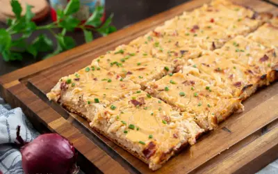 Saftiger Zwiebelkuchen vom Blech, goldbraun gebacken und mit Schnittlauch bestreut. Ein Genuss für jeden Anlass!