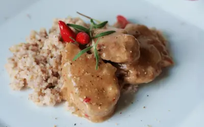 Polędwiczki wieprzowe w sosie własnym, danie Ani gotuje, podane z kaszą i ozdobione papryczką chili i rozmarynem.