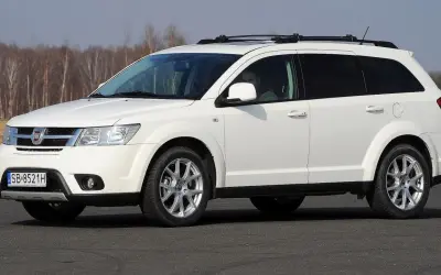Biały fiat 7 osobowy z relingami na dachu, gotowy na rodzinną podróż.