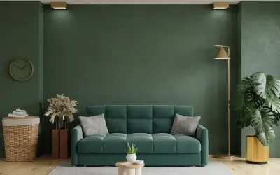 Un acogedor salón con un sofá verde, plantas y una lámpara dorada.