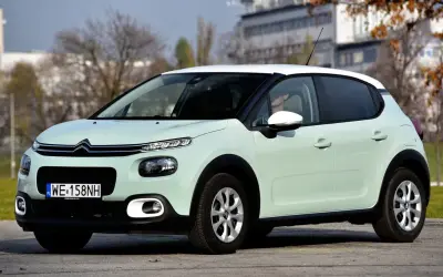 Jasnozielony Citroen C3 z białym dachem, na którym opony wyglądają na zimowe. Idealny do miasta, ale jakie opony wybrać na dalsze trasy?