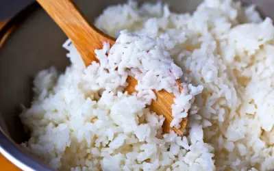 Drewniana łyżka miesza puszysty, biały ryż. Idealny do sushi, wygląda na bardzo dobry ryż.