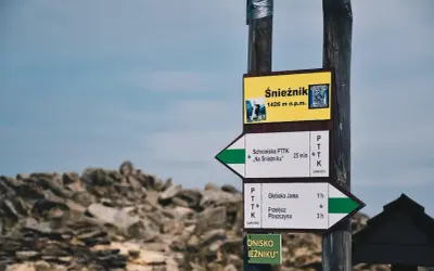 Znak drogowskazów na Śnieżnik, 1426 m n.p.m. Wskazuje drogę do schroniska "Na Śnieżniku" i na Przełęcz Płoszczynę.