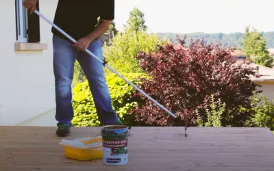 Application d'un saturateur sur une terrasse en bois. Le rouleau est en action pour un nettoyage et une protection parfaits.