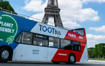 Ekologiczny autobus wycieczkowy Tootbus w Paryżu, z widoczną Wieżą Eiffla w tle. Idealny sposób na zwiedzanie Paryża samochodem.