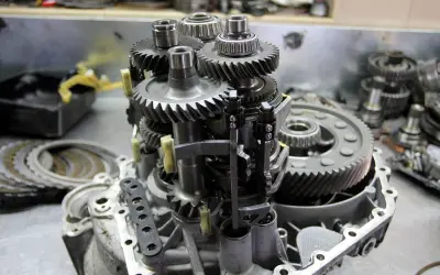 Mechanizm skrzyni biegów z widocznymi kołami zębatymi i łożyskami. Objawy zużycia łożyska skrzyni biegów mogą być różne.